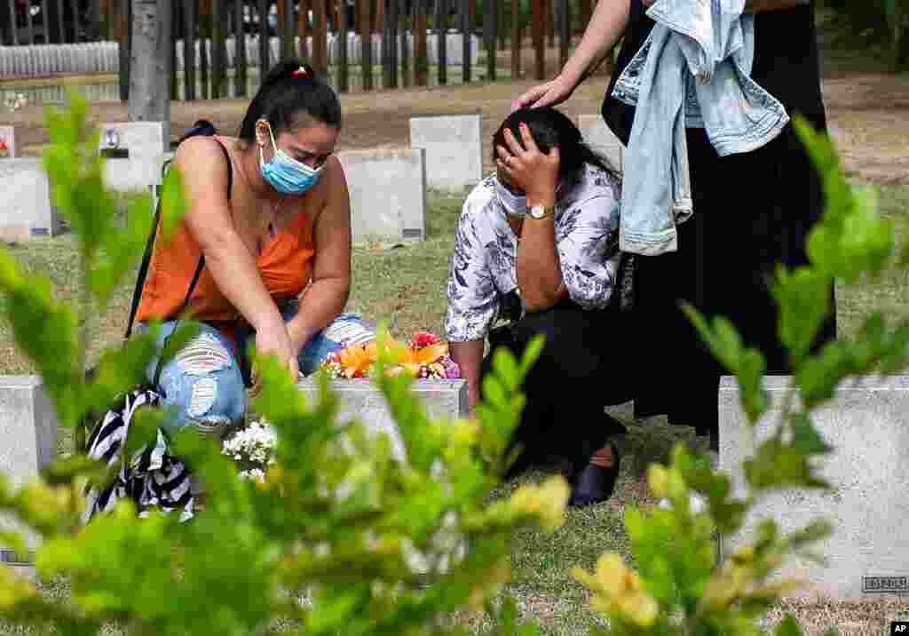 Vera Lucia Neia (centro) llora en la tumba de su madre Mar&#237;a Auxiliadora, de 76 a&#241;os, quien Neia dice que muri&#243; de COVID-19, en el cementerio de Penitencia en R&#237;o de Janeiro, Brasil. Noviembre 2, 2020. 