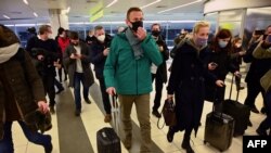 El líder opositor ruso Alexei Navalny y su esposa Yulia caminan hacia el punto de control de pasaportes en el aeropuerto Sheremetyevo de Rusia, a su llegada de Berlín, el 17 de enero de 2021. Navalny fue detenido de inmediato.