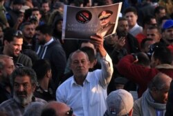 FILE - Supporters of Libyan military strongman Khalifa Haftar (image) take part in a demonstration in Benghazi, eastern Libya, against what they see as Turkey's intervention in their country's affairs, Feb. 14, 2020.