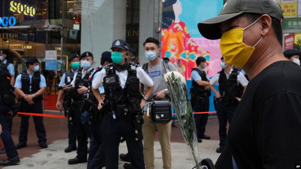 2021 年 7 月 2 日，一名男子手持鲜花悼念在香港刺伤一名警察的袭击者的死亡。(photo:VOA)
