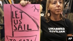 An activist holds a placard during a news conference regarding preparations of a flotilla, which is due to set sail to Gaza from Greece, in Athens June 27, 2011.