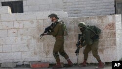 FILE - Israeli soldiers conduct a search for suspects of a shooting attack on Dec. 9, 2018, in the West Bank City of Ramallah, Dec. 10, 2018. 