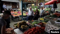 FILE - People shop at a vegetable and fruit market in Amman, Jordan, June 6, 2018. Climate change could drive up the prices of vegetables, according to a new study.