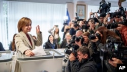 Moldova's President Maia Sandu prepares to cast her vote, in Chisinau, Moldova, Oct. 20, 2024, during a presidential election and a referendum on whether to enshrine in the Constitution the country's path to European Union membership.