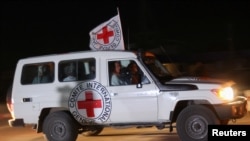 A Red Cross vehicle, as part of a convoy believed to be carrying hostages abducted by Hamas militants on October 7, arrives at the Rafah border, amid a hostages-prisoners swap deal between Hamas and Israel, as seen from southern Gaza Strip November 24, 2023.