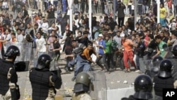 Iraqi riot police officers prevent anti-government protesters from entering the heavily guarded Green Zone during a demonstration in Baghdad, February 25, 2011