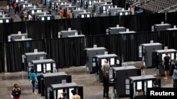 People cast their ballots during early voting for the upcoming presidential elections inside of The Atlanta Hawks' State Farm Arena in Atlanta, Georgia, U.S., October 12, 2020.