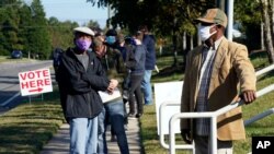 Early voters wait to cast their ballots at the South Regional Library polling location in Durham, N.C., Oct. 15, 2020. 