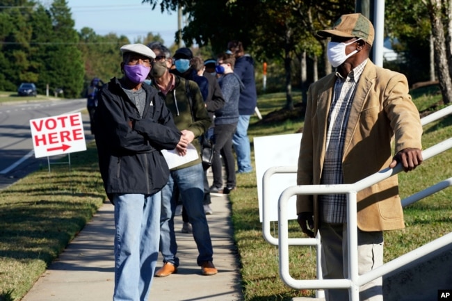 Kuzey Carolina eyaletinin Durham kentinde seçmenler, oy kullanma merkezine dönüştürülen bir kütüphanede erken oy kullanmak için sıraya girmiş.
