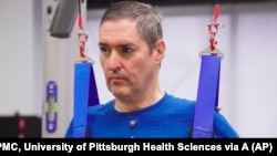 This image from video provided by UPMC and University of Pittsburgh Health Sciences shows Doug McCullough, who has spinal muscular atrophy, during tests of experimental spinal cord stimulation to improve muscle function in Pittsburgh, on March 14, 2023. 