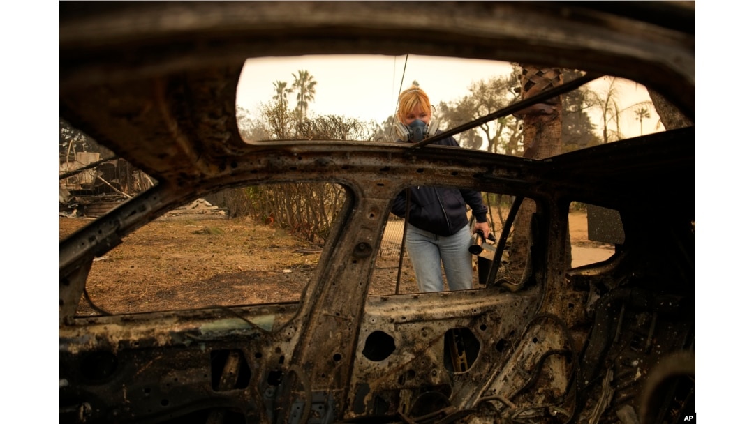 Lissa Renn looks at the remains of a car in Altadena, California, Jan. 9, 2025.