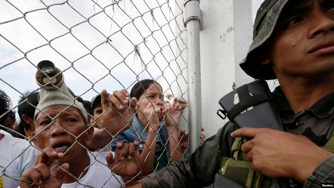 Warga mengantre obat dan bantuan di bandar udara Tacloban (11/11). (AP/Bullit Marquez)
