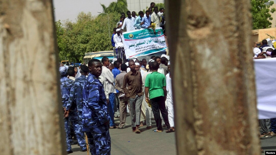Polisi (berseragam biru) mengawasi pemrotes saat melakukan aksi unjuk rasa di Khartoum, Sudan, 22 Mei 2015. (Foto: dok).