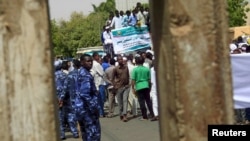 Polisi (berseragam biru) mengawasi pemrotes saat melakukan aksi unjuk rasa di Khartoum, Sudan, 22 Mei 2015. (Foto: dok).