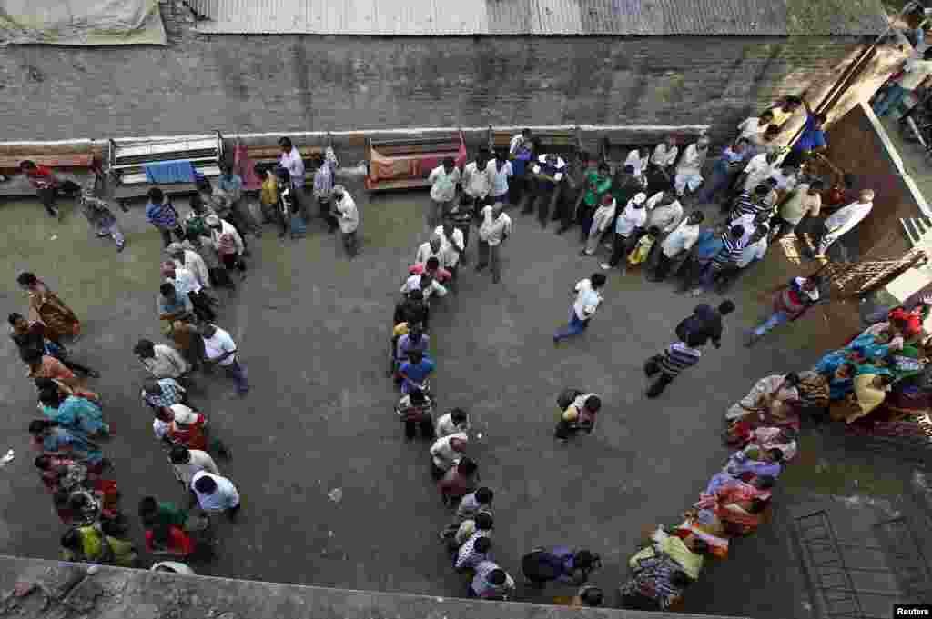 Voters line up to cast their votes outside a polling station at Howrah district in the eastern Indian state of West Bengal, April 30, 2014. 