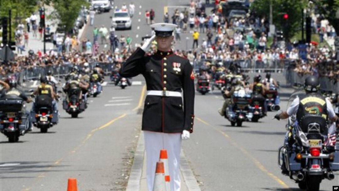 Seorang perwira Angkatan Laut memberikan penghormatan kepada para pengendara sepeda motor yang melintas di jalan saat parade tahunan 'Rolling Thunder' memperingati Memorial Day di Washington (27/5).