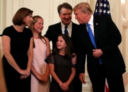 FILE - President Donald Trump talks with Judge Brett Kavanaugh his Supreme Court nominee, and his family in the East Room of the White House, July 9, 2018, in Washington.