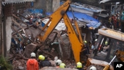 Rescuers clear the debris to find any residents possibly still trapped after a three-story dilapidated building collapsed following heavy monsoon rains n Mumbai, India, Thursday, June 10, 2021. (AP Photo/Rafiq Maqbool)