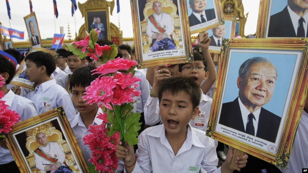 Cambodian students hold portraits of former King Norodom Sihanouk during an Independence Day celebration in Phnom Penh, Cambodia, Nov. 9, 2011.