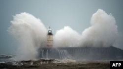 Waves crash over Newhaven Lighthouse on the south coast of England on February 9, 2020, as Storm Ciara swept over the country. 