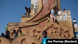 Crianças brincam num monumento de Bissau, capital da Guiné-Bissau.