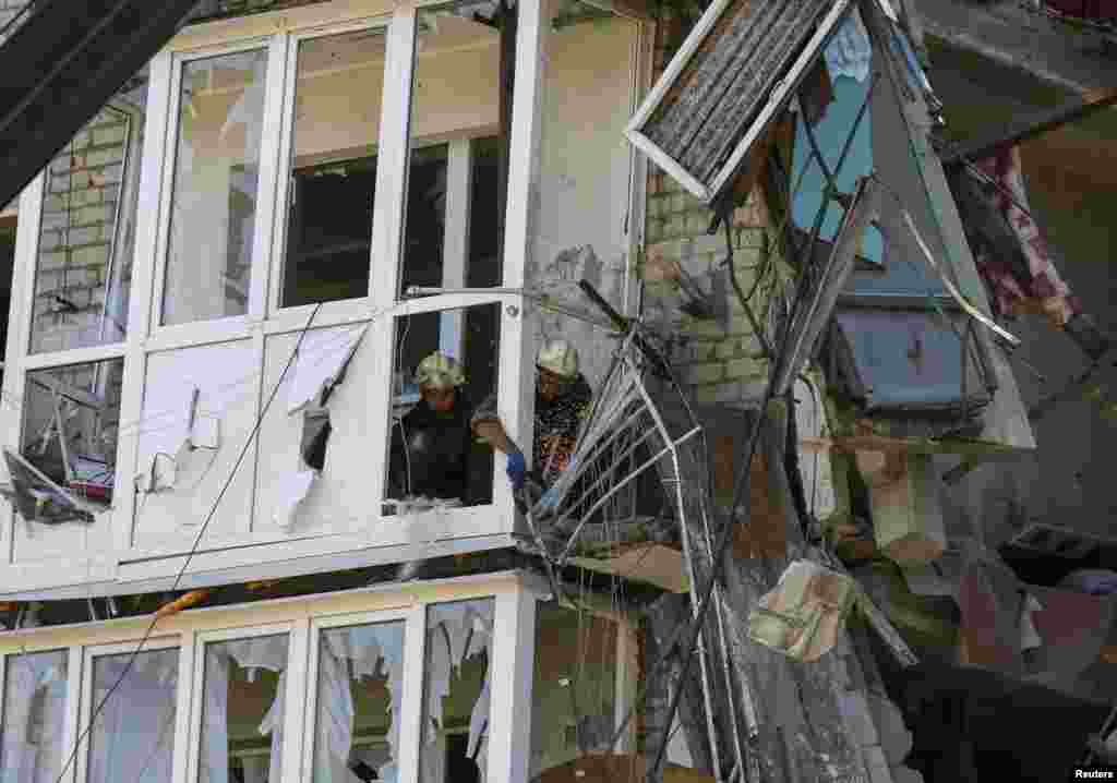 Rescuers remove damaged materials from a shattered five-story building that was damaged by a recent shelling, near the eastern Ukrainian town of Slovyansk, July 16, 2014.