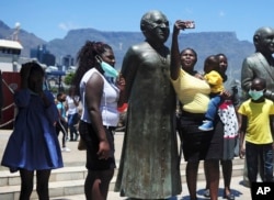 People take photos at a statue of Anglican Archbishop Desmond Tutu at the V&A Waterfront in Cape Town, South Africa, Sunday, Dec. 26, 2021.(AP)