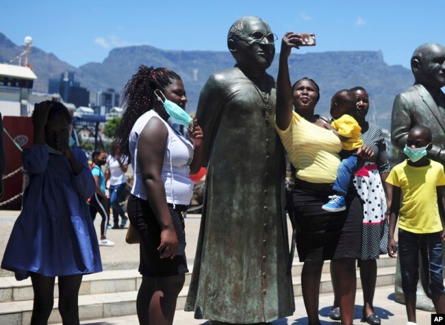 People take photos at a statue of Anglican Archbishop Desmond Tutu at the V&A Waterfront in Cape Town, South Africa, Sunday, Dec. 26, 2021.(AP)