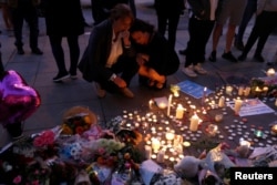 Women pay their respects to all those affected by the bomb attack, following a vigil in central Manchester, Britain, May 23, 2017.
