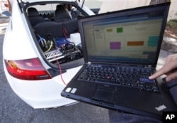 Stanford graduate student Mick Kritayakirana uses a laptop computer as he demonstrates the computer system inside a driverless car on the Stanford University campus in Palo Alto, Calif.