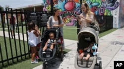 兩名佛羅里達邁亞密居民7月29日帶她們的嬰孩上街。
