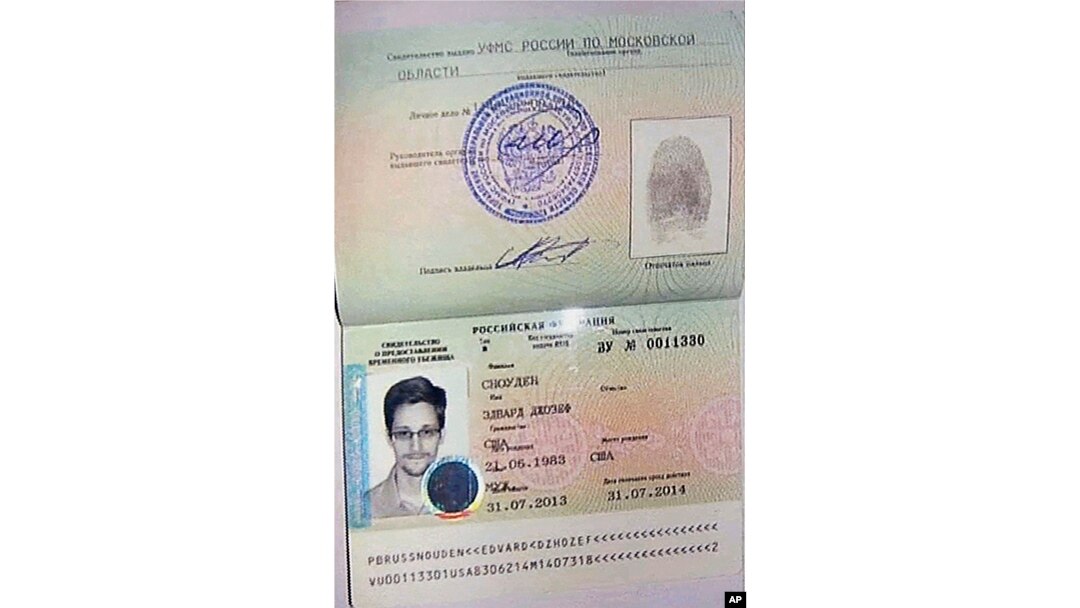 An image taken from AP Television shows a copy of a temporary document that allows Edward Snowden to cross the border into Russia, held by Russian lawyer Anatoly Kucherena visiting Snowden at Sheremetyevo airport outside Moscow, August 1, 2013.