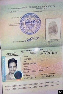 An image taken from AP Television shows a copy of a temporary document that allows Edward Snowden to cross the border into Russia, held by Russian lawyer Anatoly Kucherena visiting Snowden at Sheremetyevo airport outside Moscow, August 1, 2013.