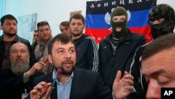 Denis Pushilin, foreground center, spokesman of the self-appointed Donetsk People’s Republic, speaks to reporters inside the regional administration building seized earlier in Donetsk, Ukraine, April 18, 2014. 