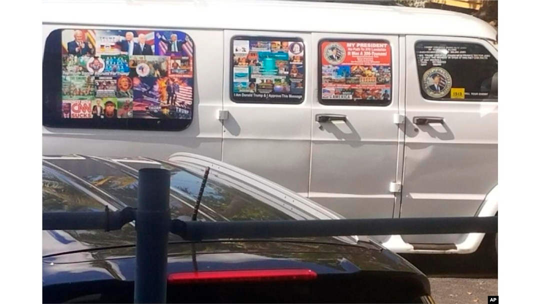 FILE - This Nov. 1, 2017, photo shows a van with windows covered with an assortment of stickers in Well, Florida. Federal authorities took Cesar Sayoc into custody on Oct. 26, 2018, and confiscated his van, which appears to be the same one.