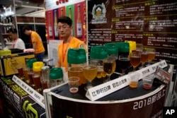 A vendor waits for visitors at a beer booth at the 2018 Craft Beer of China Exhibition in Shanghai, May 16, 2018.