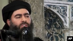 This file image made from video posted on a militant website in July 2014, which has been authenticated based on its contents and other AP reporting, purports to show Abu Bakr al-Baghdadi, the leader of the Islamic State group, delivering a sermon at a mosque in Mosul, Iraq. 