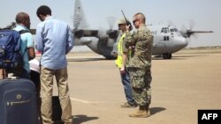 A U.S. army soldier stands guard by an aircraft as American nationals await evacuation from, Juba, South Sudan, Dec. 21, 2013.