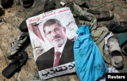 A poster of deposed Egyptian president Mohamed Morsi lies amid debris of a cleared protest camp of his supporters in Cairo Aug. 15, 2013.