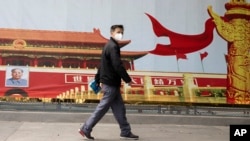 湖北武汉一名居民走过街头一幅北京天安门的招贴画。