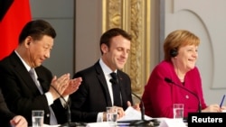 French President Emmanuel Macron, Chinese President Xi Jinping and German Chancellor Angela Merkel hold a news conference at the Elysee presidential palace in Paris, March 26, 2019. 