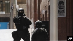 Polisi anti teror Australia melakukan operasi untuk membebaskan setidaknya 13 sandera di distrik Martin Place di kota Sydney, Senin (15/12). 