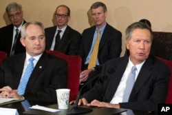 FILE – Ohio Gov. John Kasich, front right, and Ohio Senate President Keith Faber, front left, both Republicans, discuss the state budget, June 26, 2015, at the Statehouse in Columbus, Ohio. Ohio says it will resume executions using a three-drug combination.