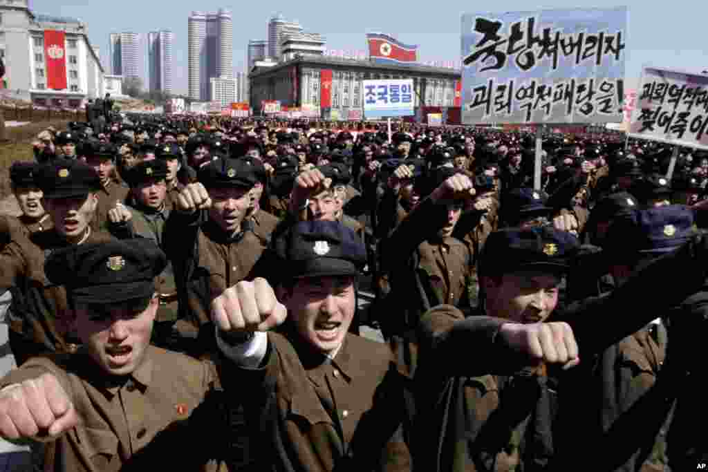 University students punch the air as they march through Kim Il Sung Square in downtown Pyongyang, North Korea, March 29, 2013. 