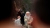 Arhiva - Mitropolit Amfilohije Radović, među vernicima, baca drveni krst u reku Ribnicu tokom proslave Bogojavljanja, u Podgorici, 19. januara 2013. (Rojters)