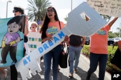 FILE-Maria Angelica Ramirez carries a large key reading "My Dream" during a protest outside the office of Sen. Marco Rubio, R-Fla., in support of Deferred Action for Childhood Arrivals (DACA), and Congress passing a clean Dream Act.
