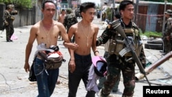 Government soldiers escort residents who were taken hostage and used as human shields by Muslim rebels of Moro National Liberation Front (MNLF) during fighting with government soldiers, in Zamboanga city in southern Philippines, Sept. 17, 2013. 