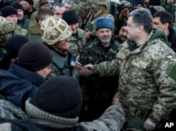 Ukrainian President Petro Poroshenko, right, shakes hands with Ukrainian servicemen in the town of Artemivsk, Ukraine, Feb. 18, 2015.