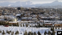 People walk up the hillside after a snow storm in Kabul, Afghanistan, Feb. 4, 2012.