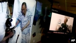 Video clips of China’s jailed Nobel Peace laureate Liu Xiaobo, left, as he lays on a bed at a hospital and, right, Liu saying wardens are taking good care of him, are displayed on a computer screen in Beijing, June 29, 2017.